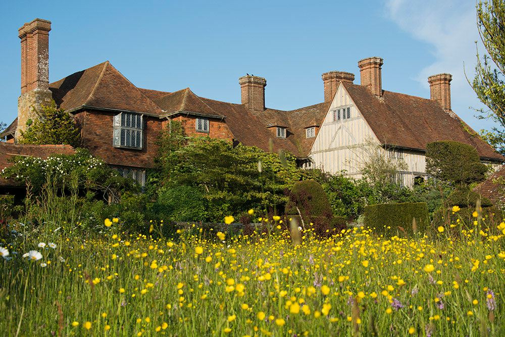 A complex or vernacular buildings with gardens in the foreground.