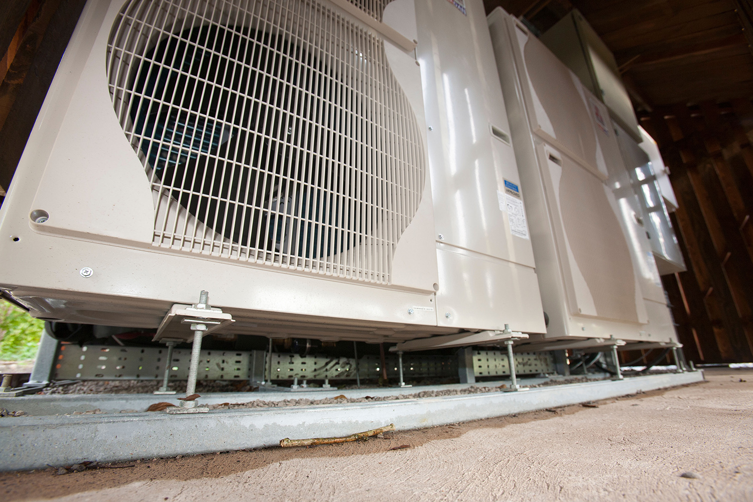 Close up photo from ground level of an air source heat pump unit.