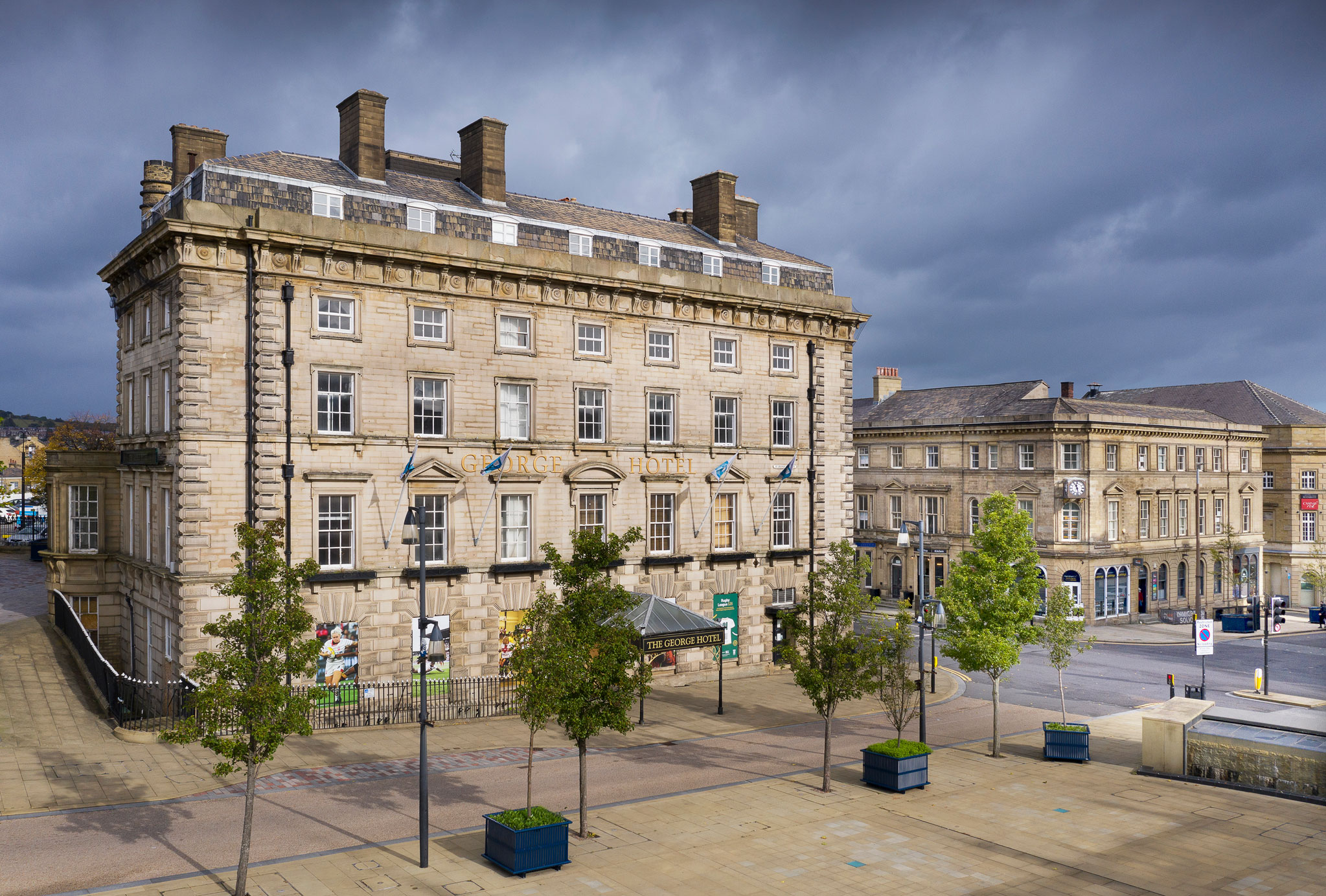 Modern colour photograph of the exterior of a four storey stone built hotel, with attic level dormers.