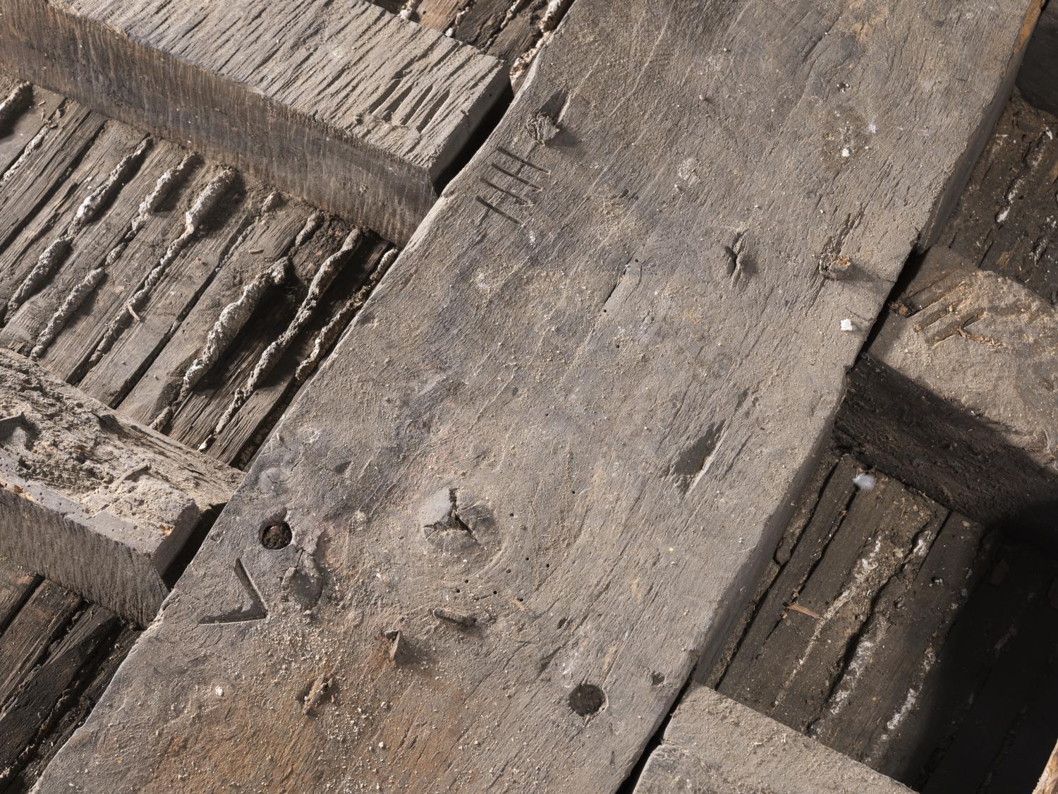 Close up of wooden floor joists showing carpenter's marks.