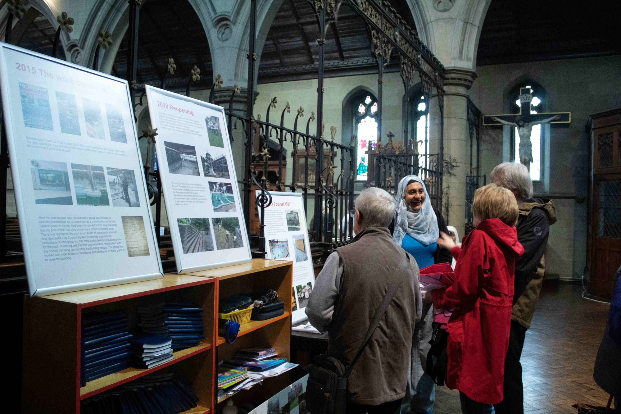 A group of 4 people talking inside a church. 
