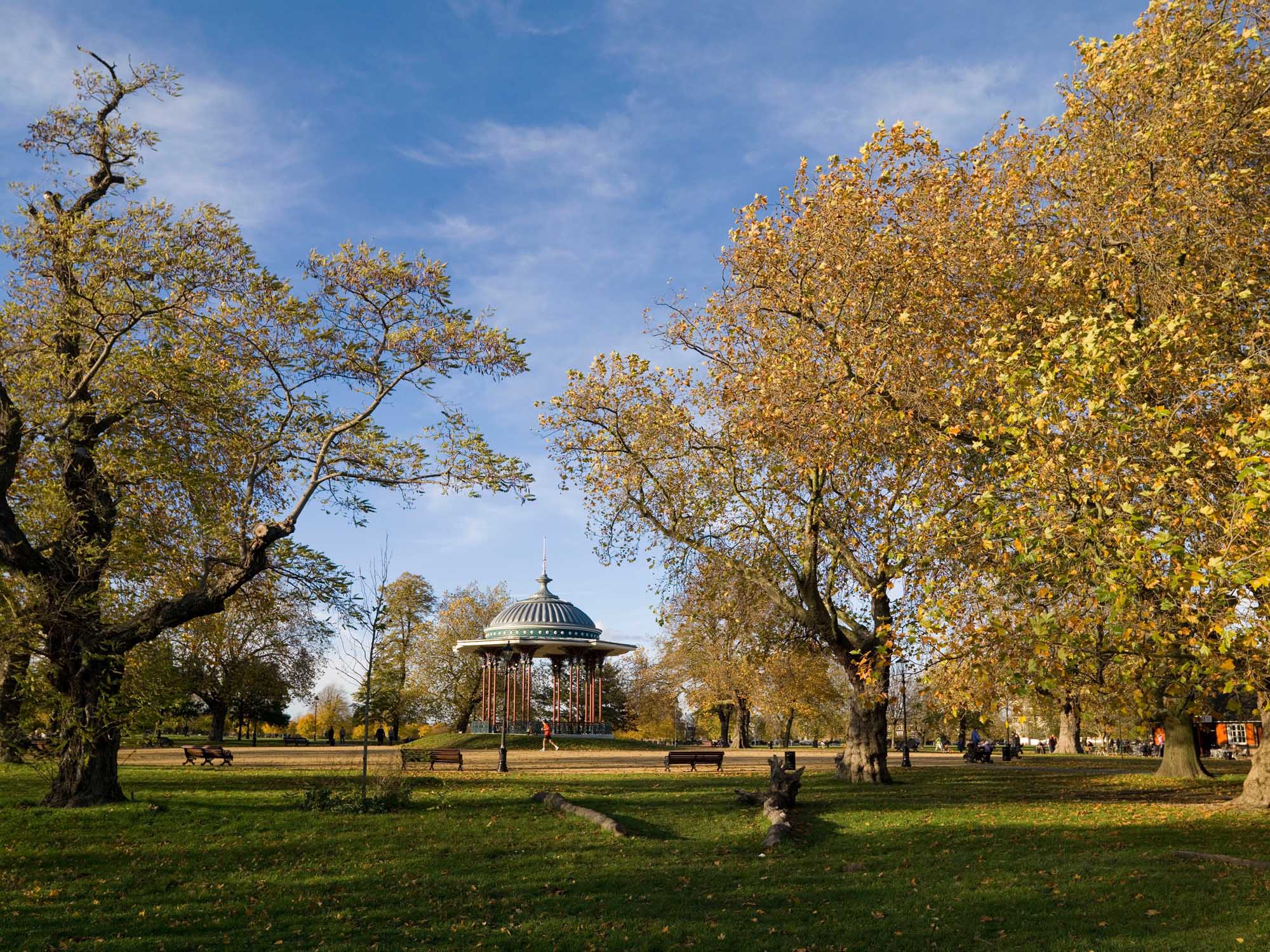 A jogger running past a bandstand at Clapham Common