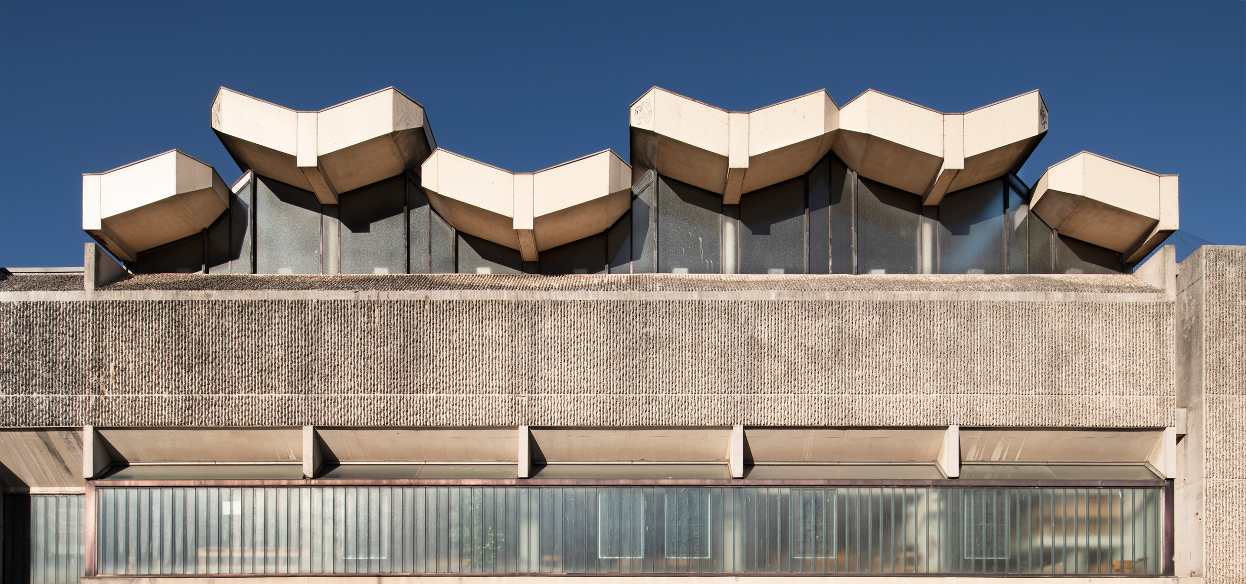 Exterior view of the roof detail of a concrete Brutalist building