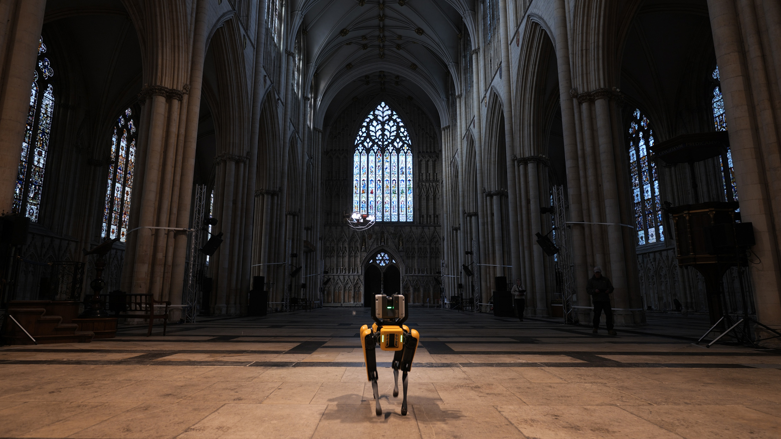 A mobile robot and flying drone within a large cathedral building.