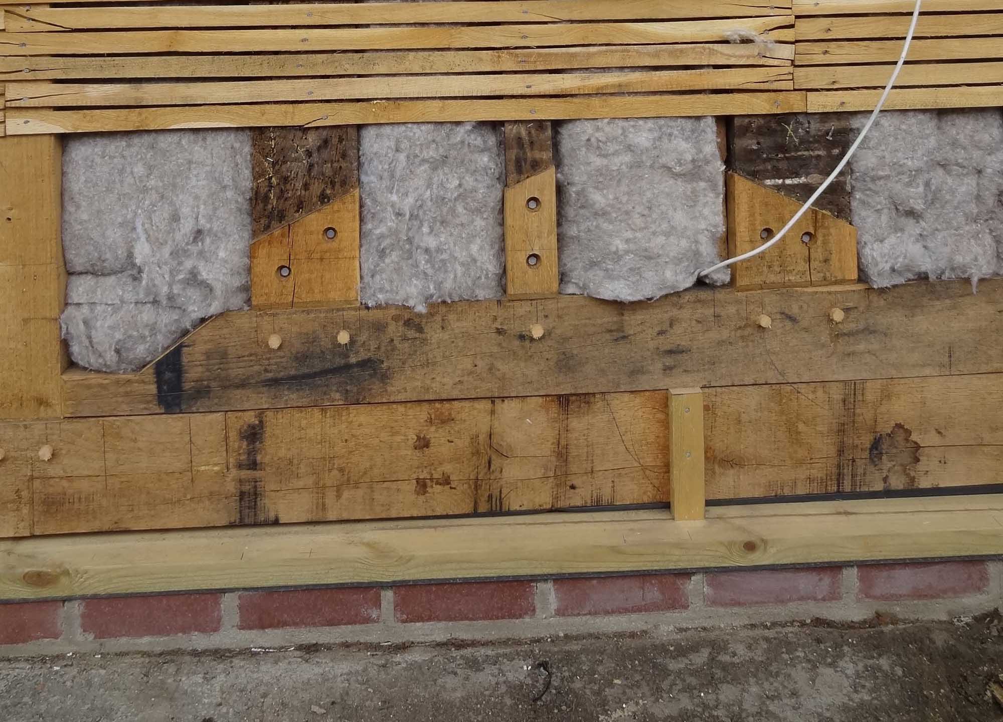 Sheep's wool has been added within the depth of the frame during the repair of this timber-framed building