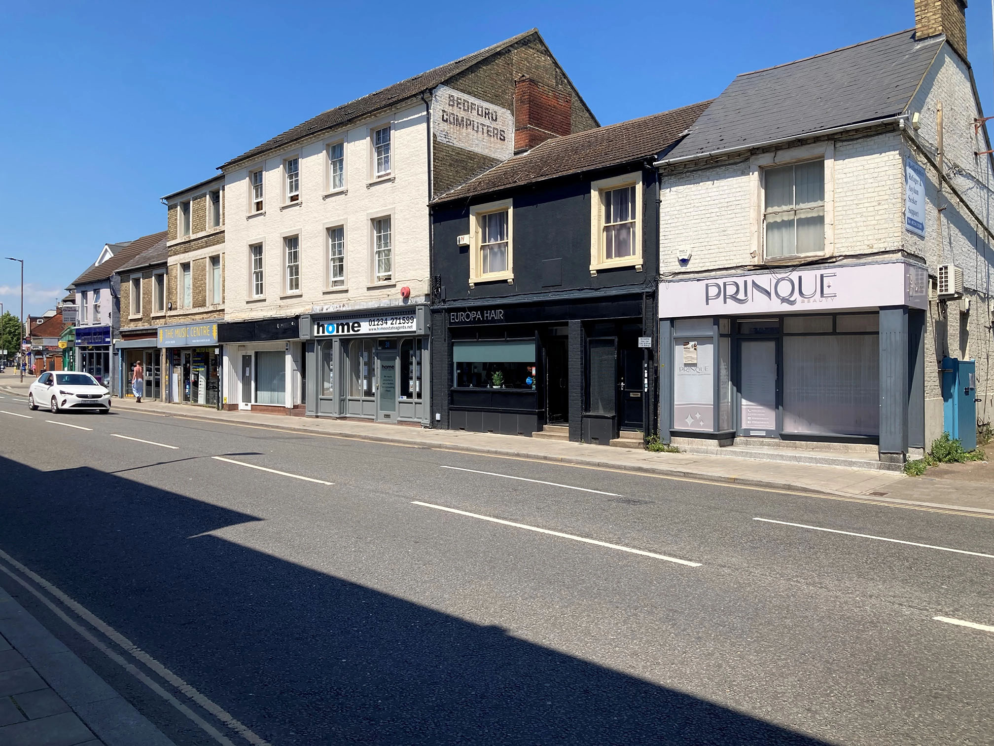 The image shows a row of shops on a Bedford street 
