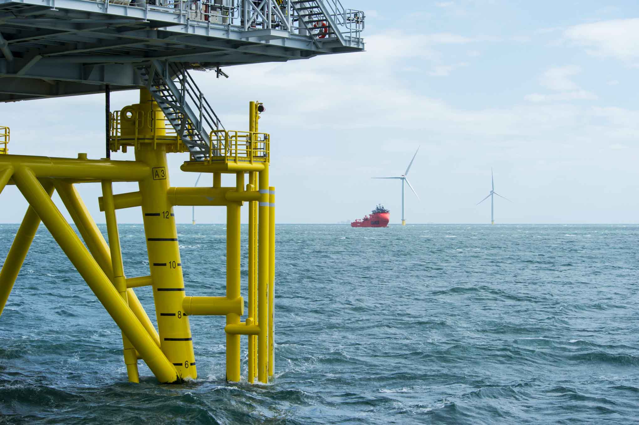 A seascape with features of a wind farm.