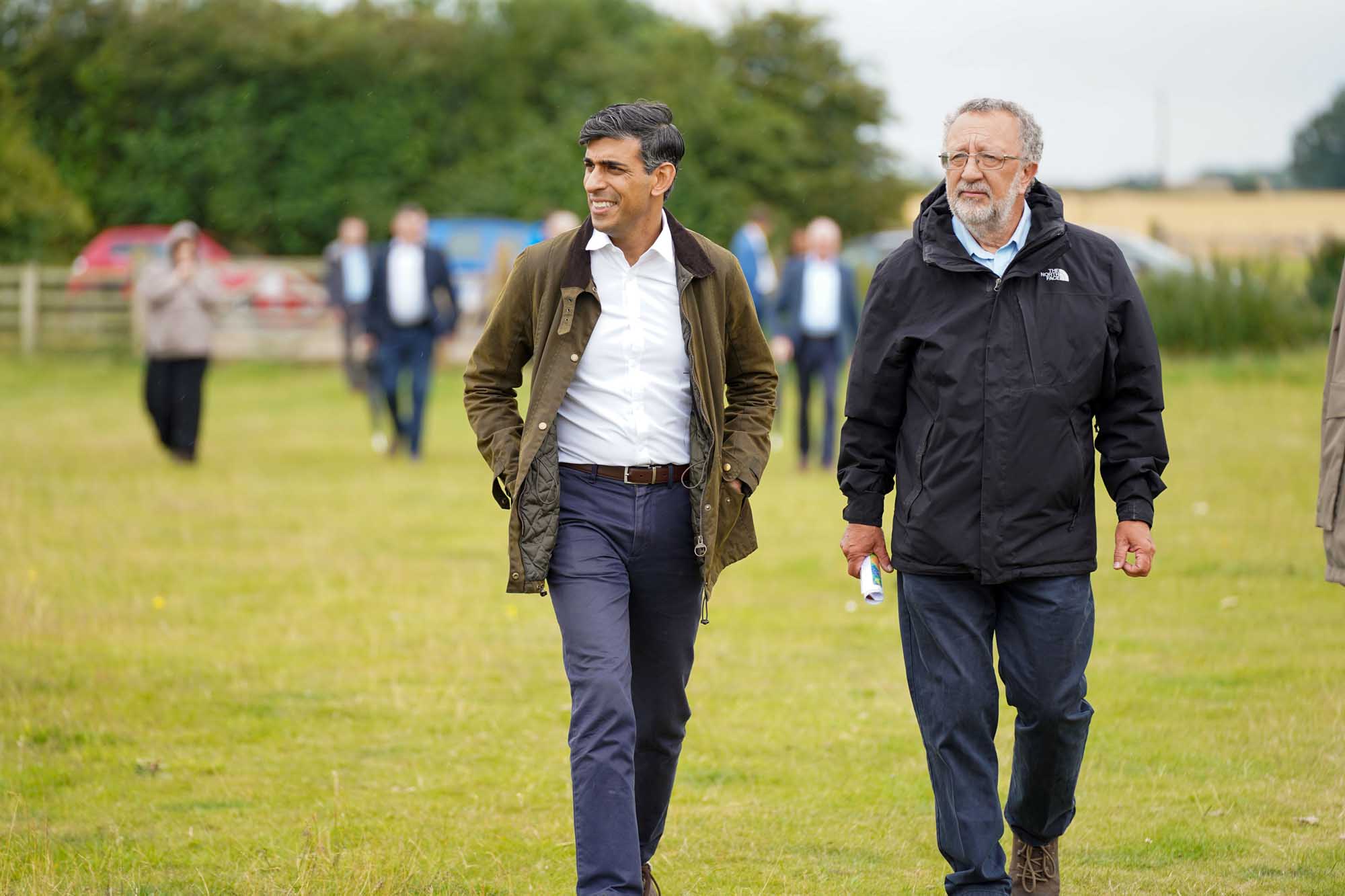 Two men standing in a field. 