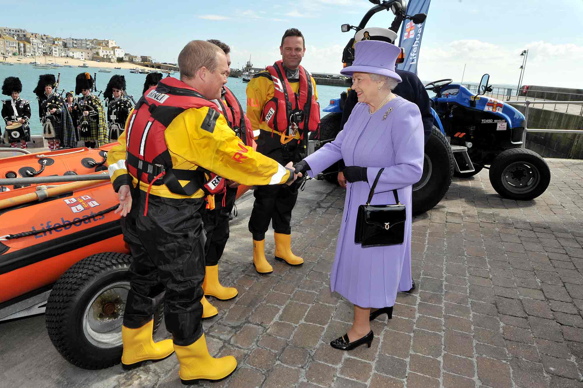 Queen Elizabeth II greets members of a lifeboat crew during a visit to the RNLI station in St Ives, Cornwall. 