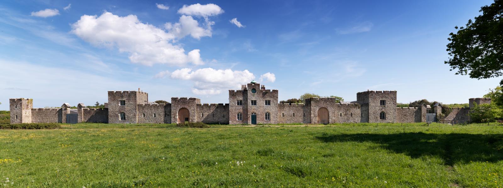 A large castle, with crenelated walls and towers.