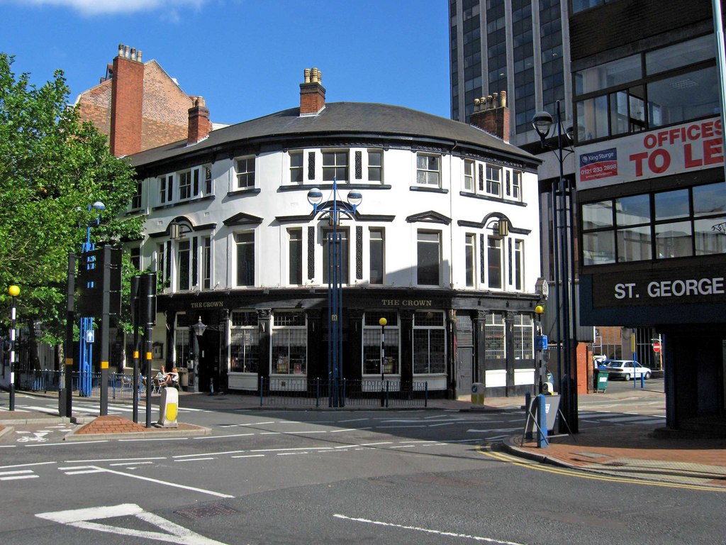 Black and white public house on the corner of a street.