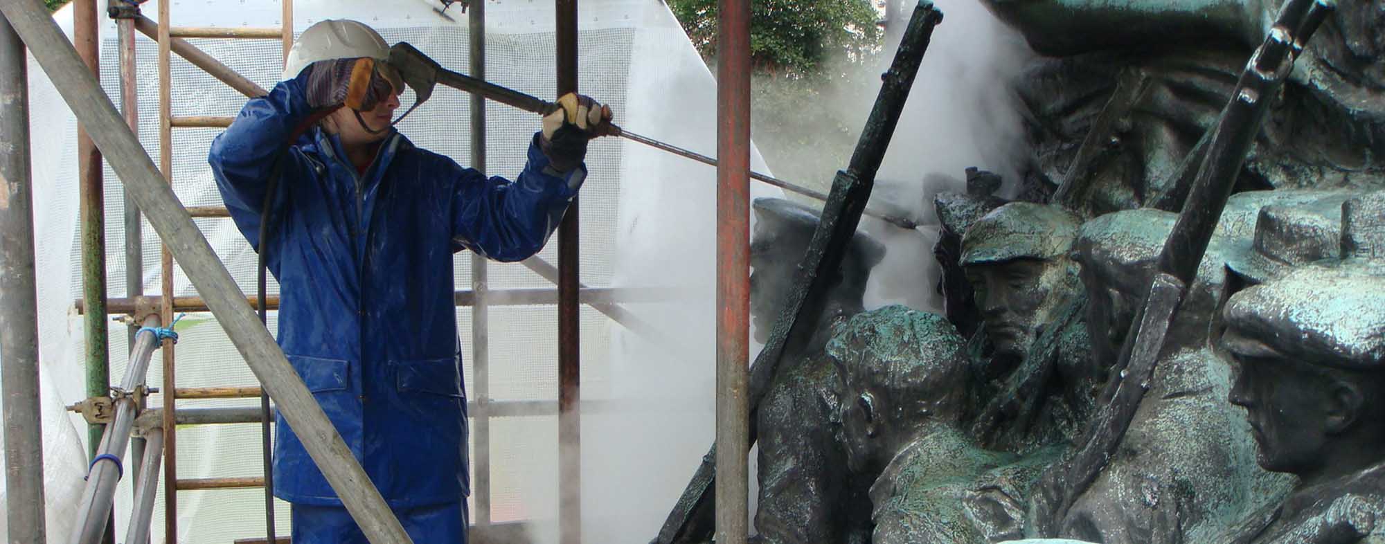 Image showing the cleaning of bronze statuary on a a war memorial with super-heated water.