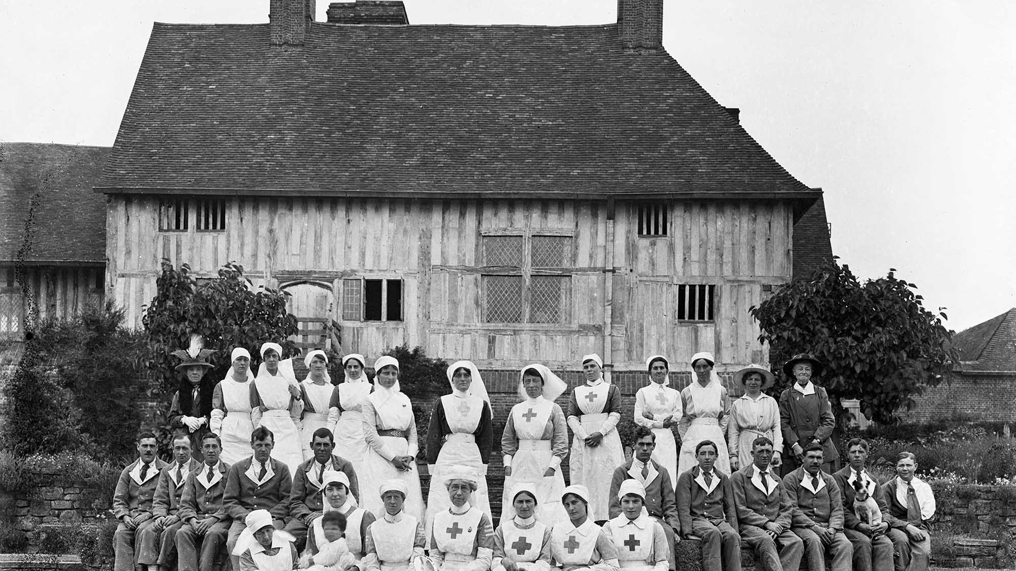 Nurses in long white uniforms with soldiers dressed in regulation convalescent uniforms at Great Dixter, East Sussex. During the war many country houses were used as hospitals and convalescent homes.