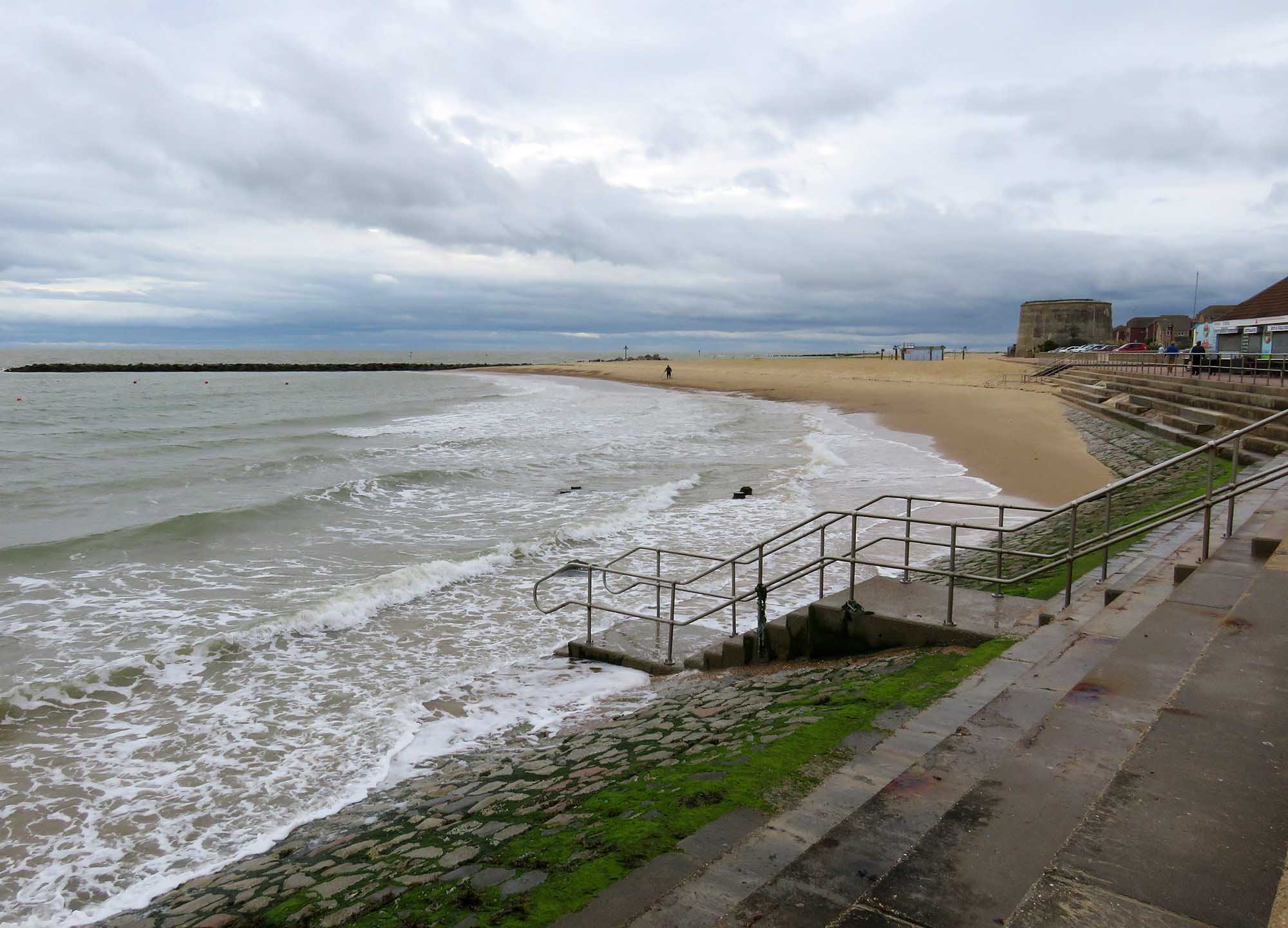 Martello Tower E in the distance showing the historic shoreline and sea.