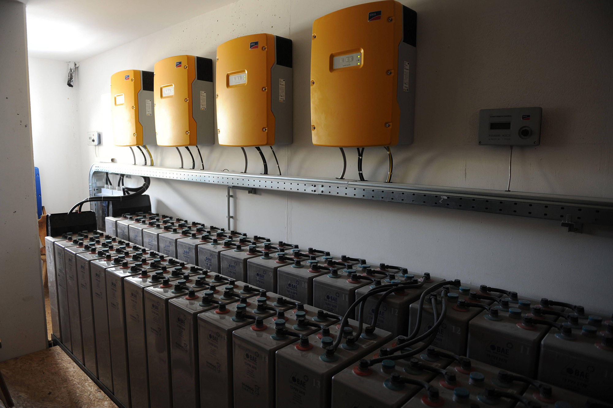 Yellow boxes mounted on a wall above two rows of black boxes.