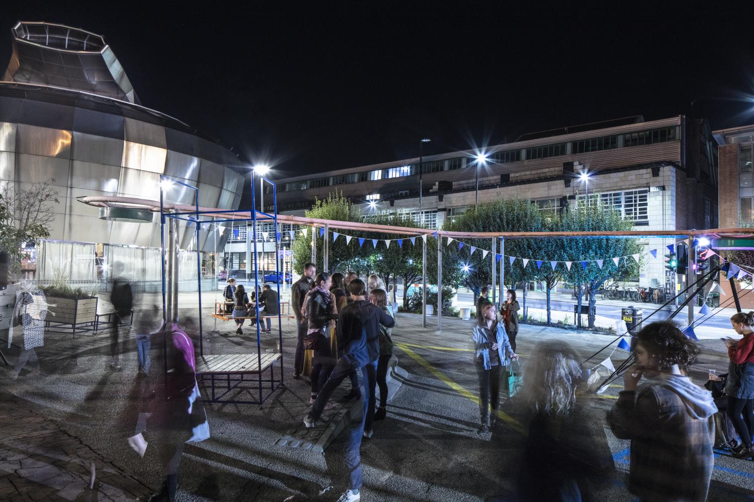 General view looking east across the outdoor space for the students union, with the Showroom and Workstation building in the background