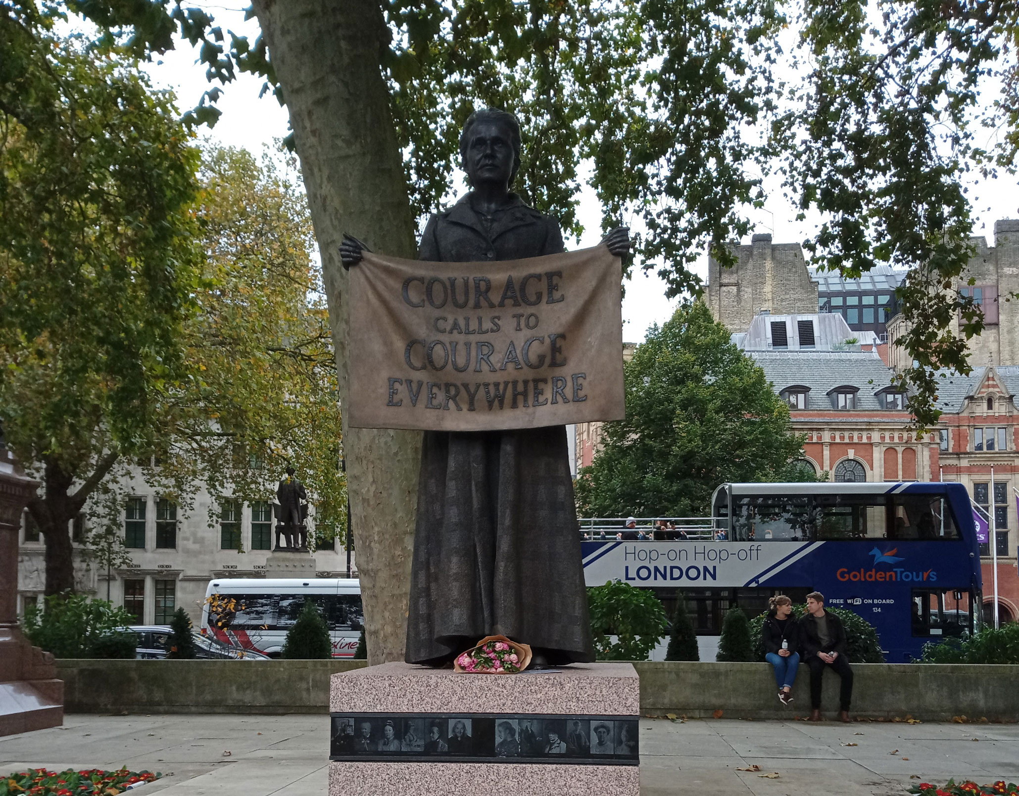 A bronze statue of a woman in Edwardian clothing holding a banner in front of her which reads 'courage calls to courage everywhere'. On the plinth are small portraits of other women.