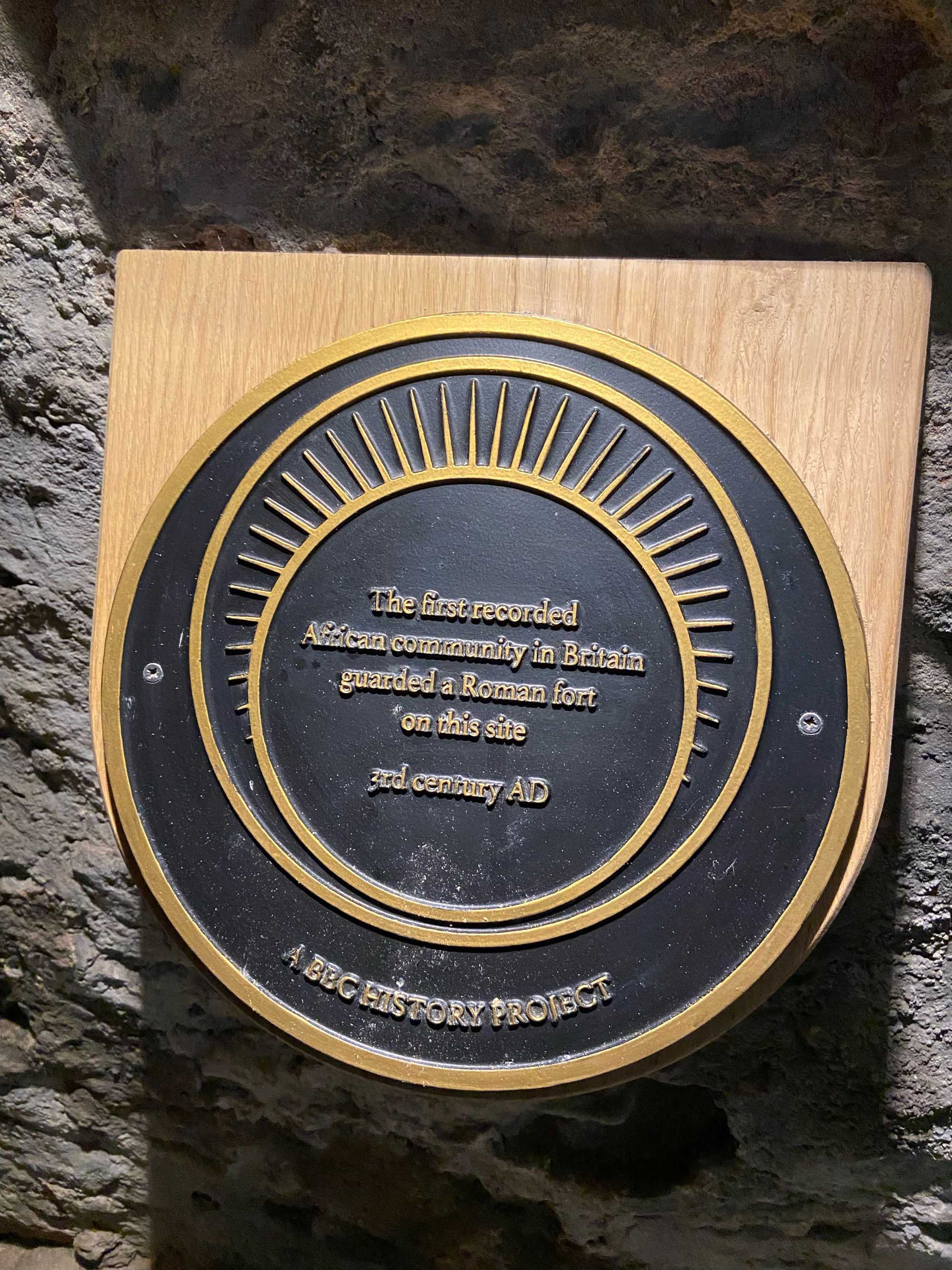 Detail of a plaque, which reads: T'he first recorded African community in Britain guarded a Roman fort on this site 3rd century AD'.