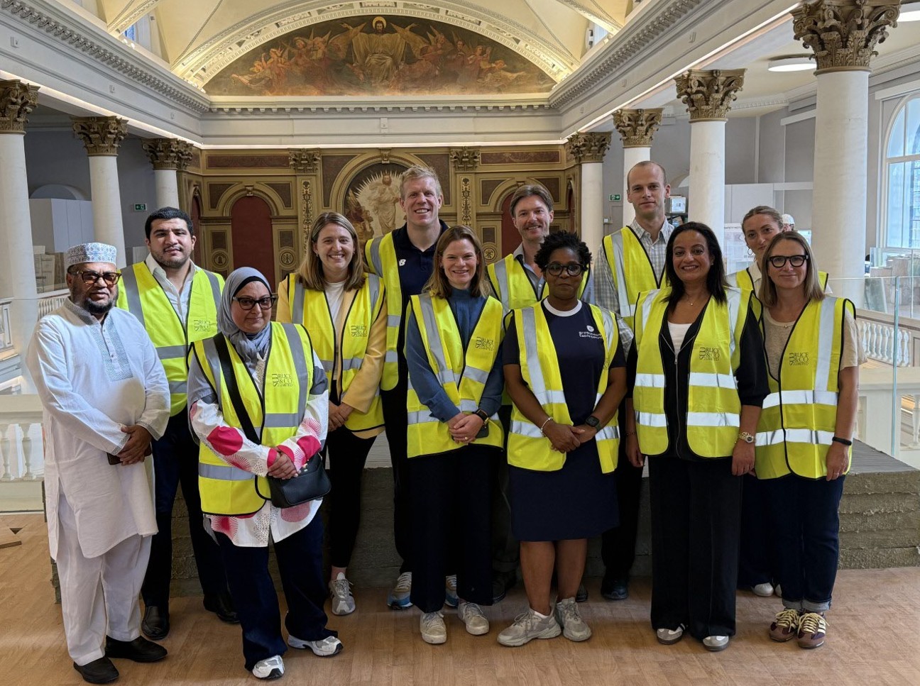 A group of people posed within the historic interior of a former church.