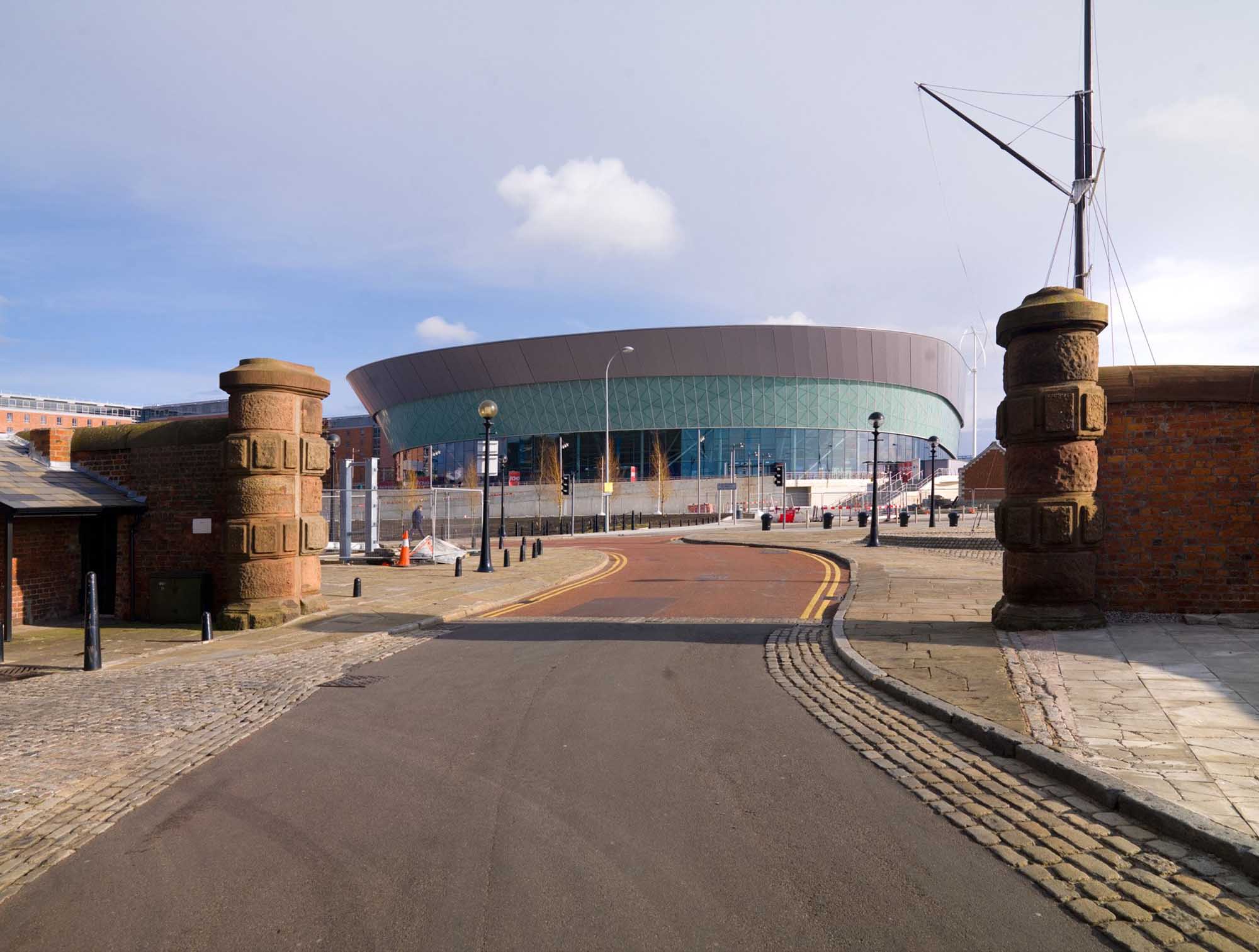 Conference centre viewed through large sandstone gateway.