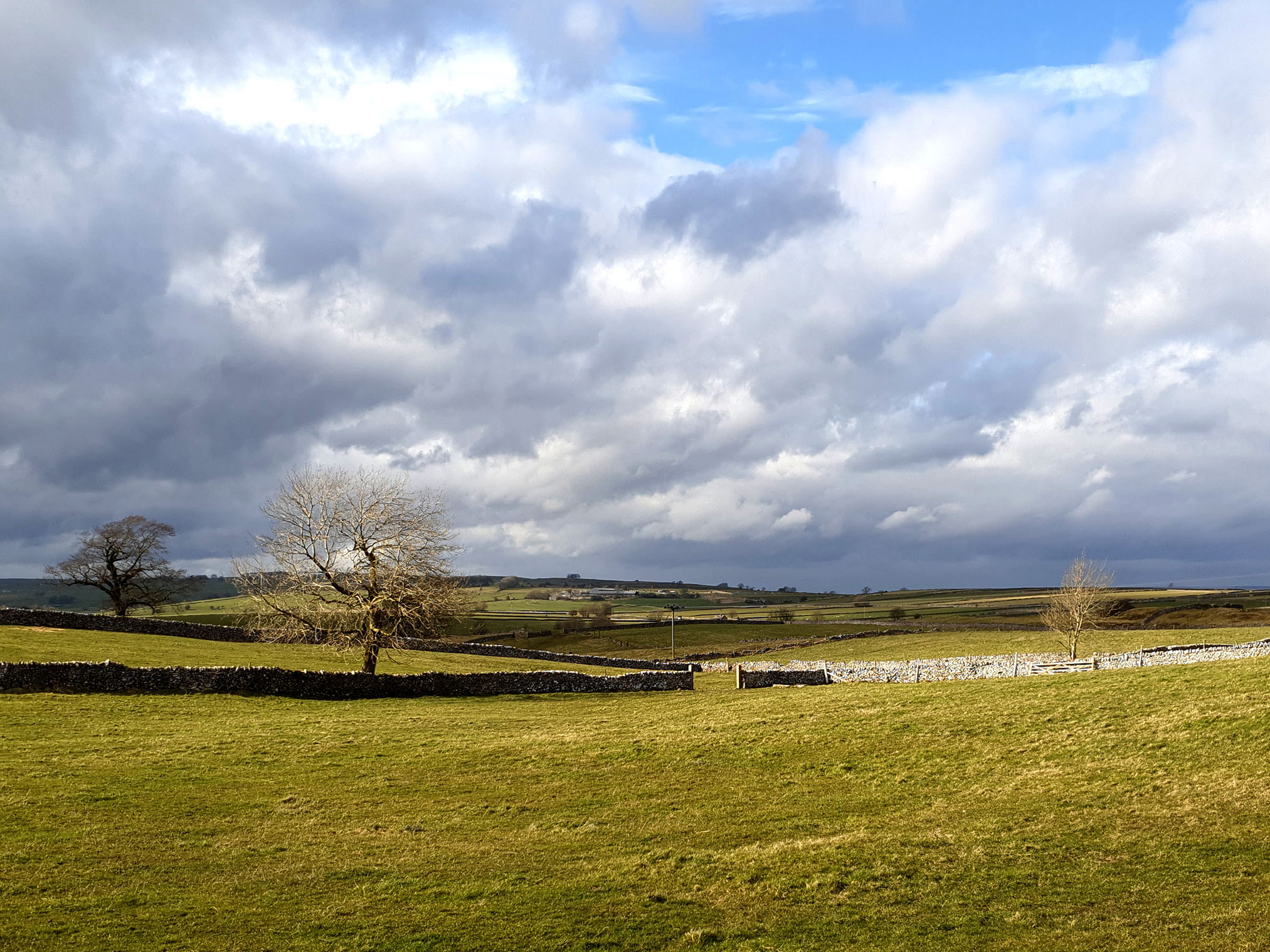 Magpie Mine, a scheduled monument near Bakewell, showing rolling fields and drystone walls.