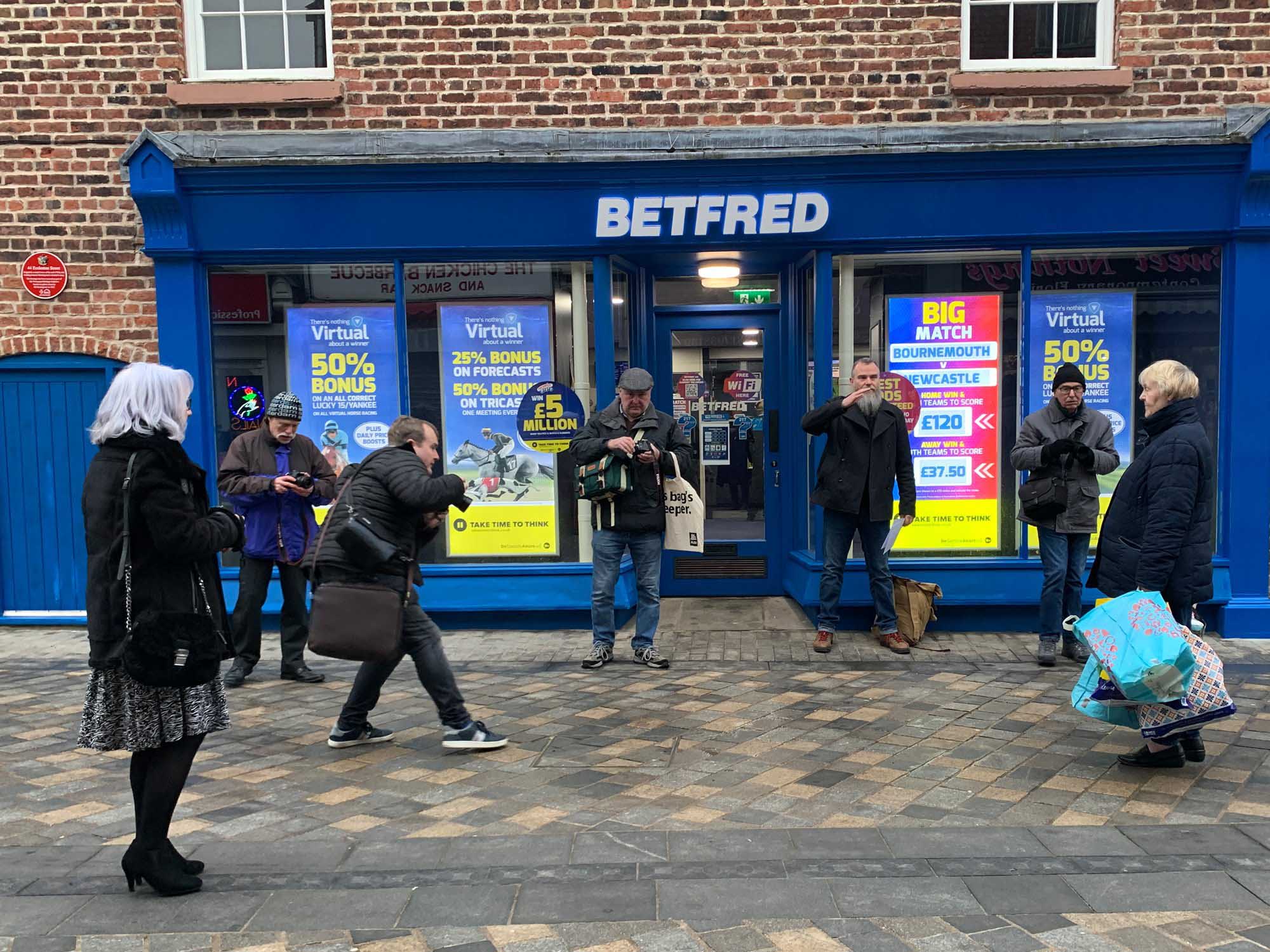Group of amateur photographers outside Betfred premises.