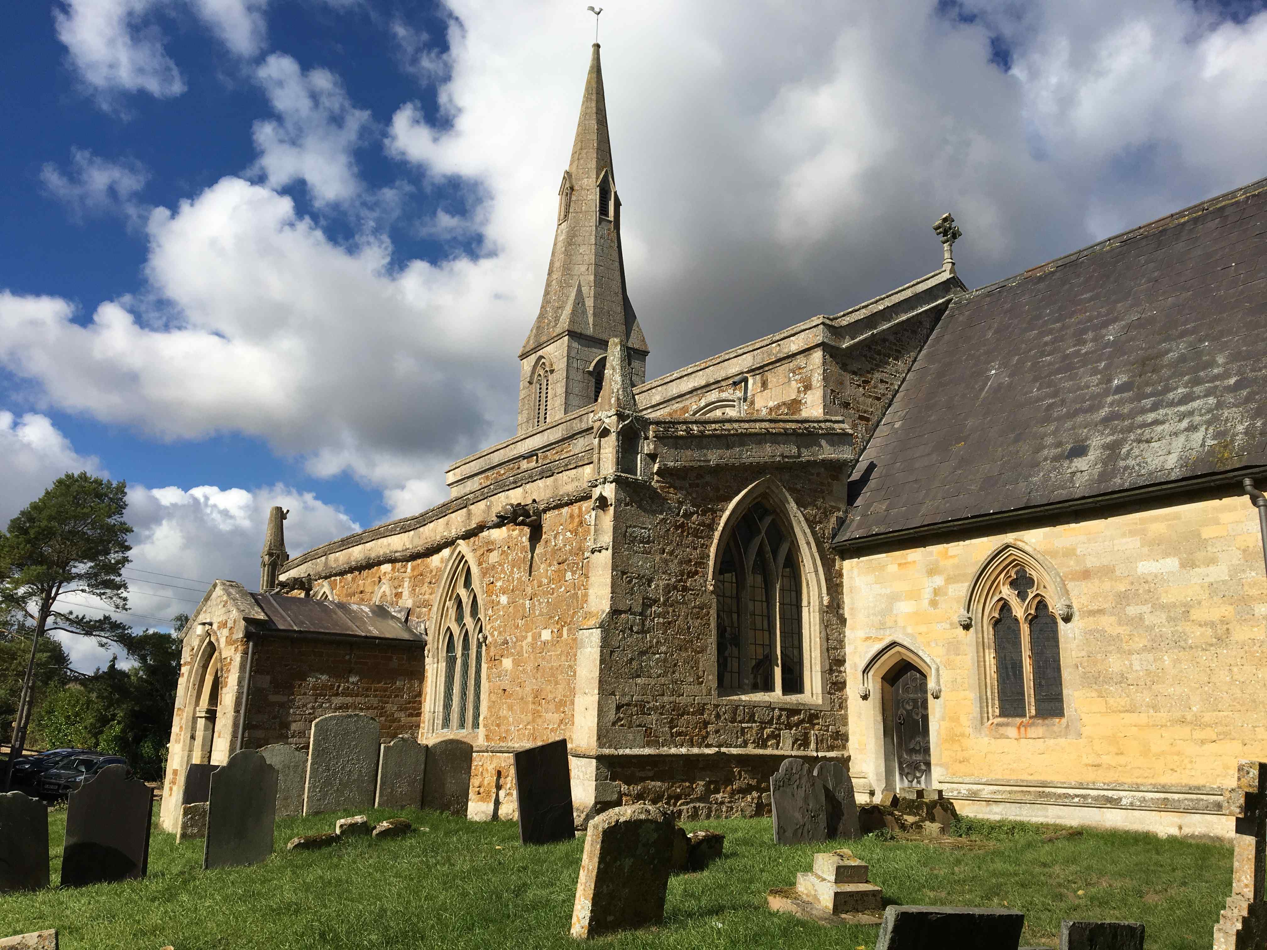 Image of the church of Coston St Andrew shown side-on against a cloudy sky.