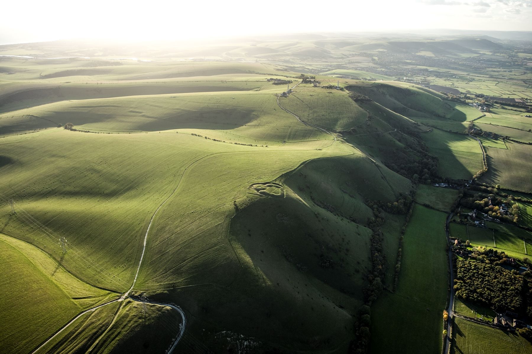 Aerial photo of the South Downs. A circular earthwork can be seen on a prominent ridge.