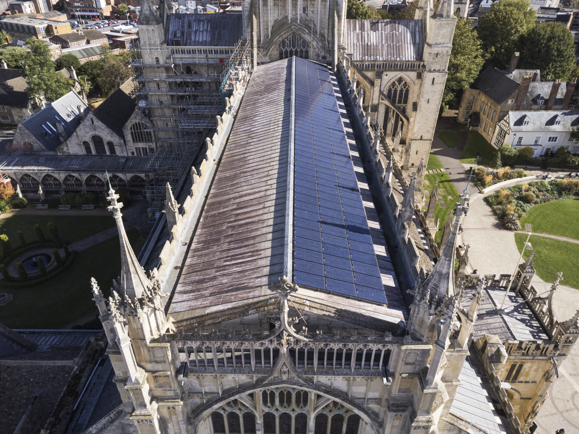 An aerial view of a cathedral roof with solar panels installed.
