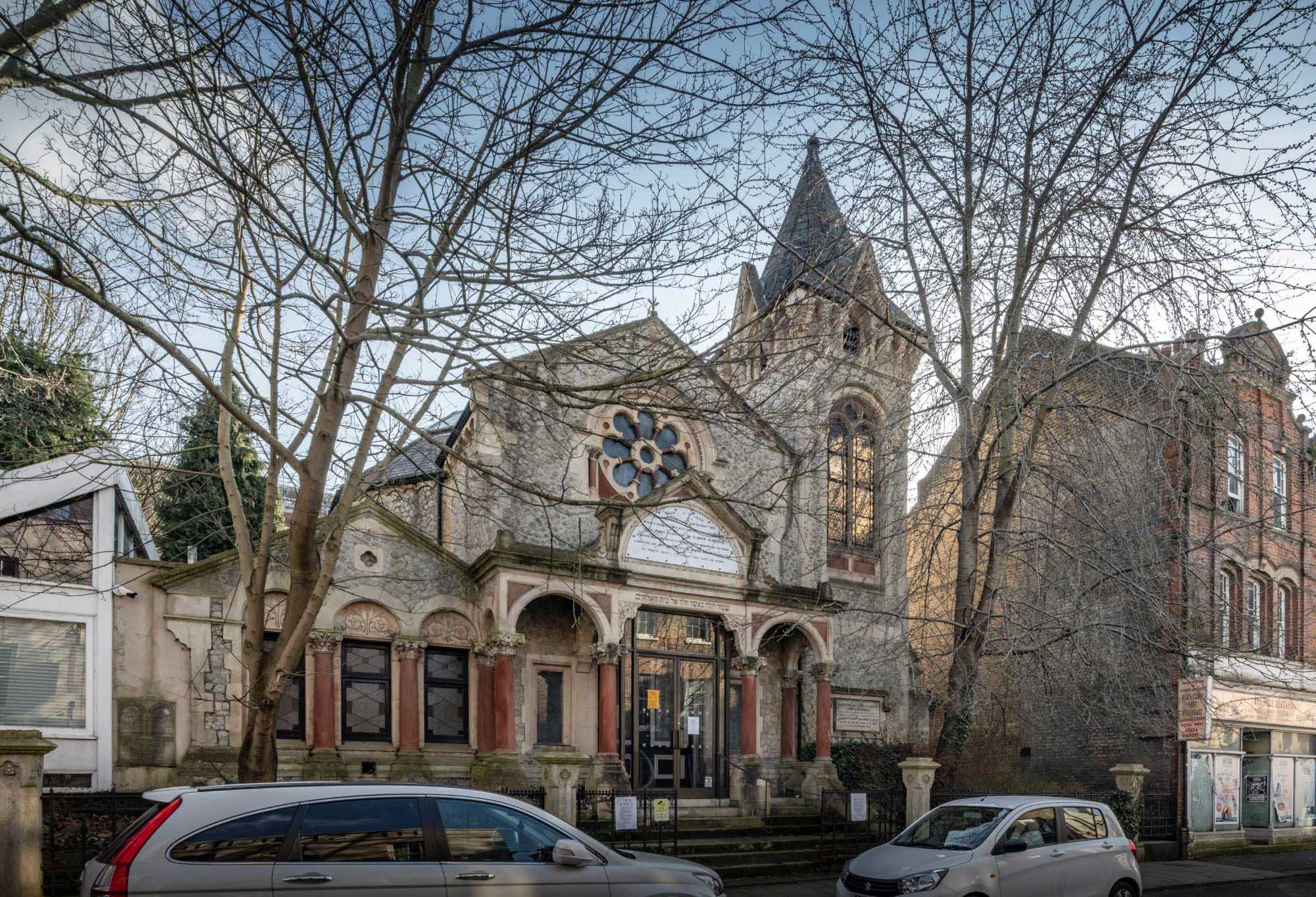 A stone building with a tower and decorative windows.