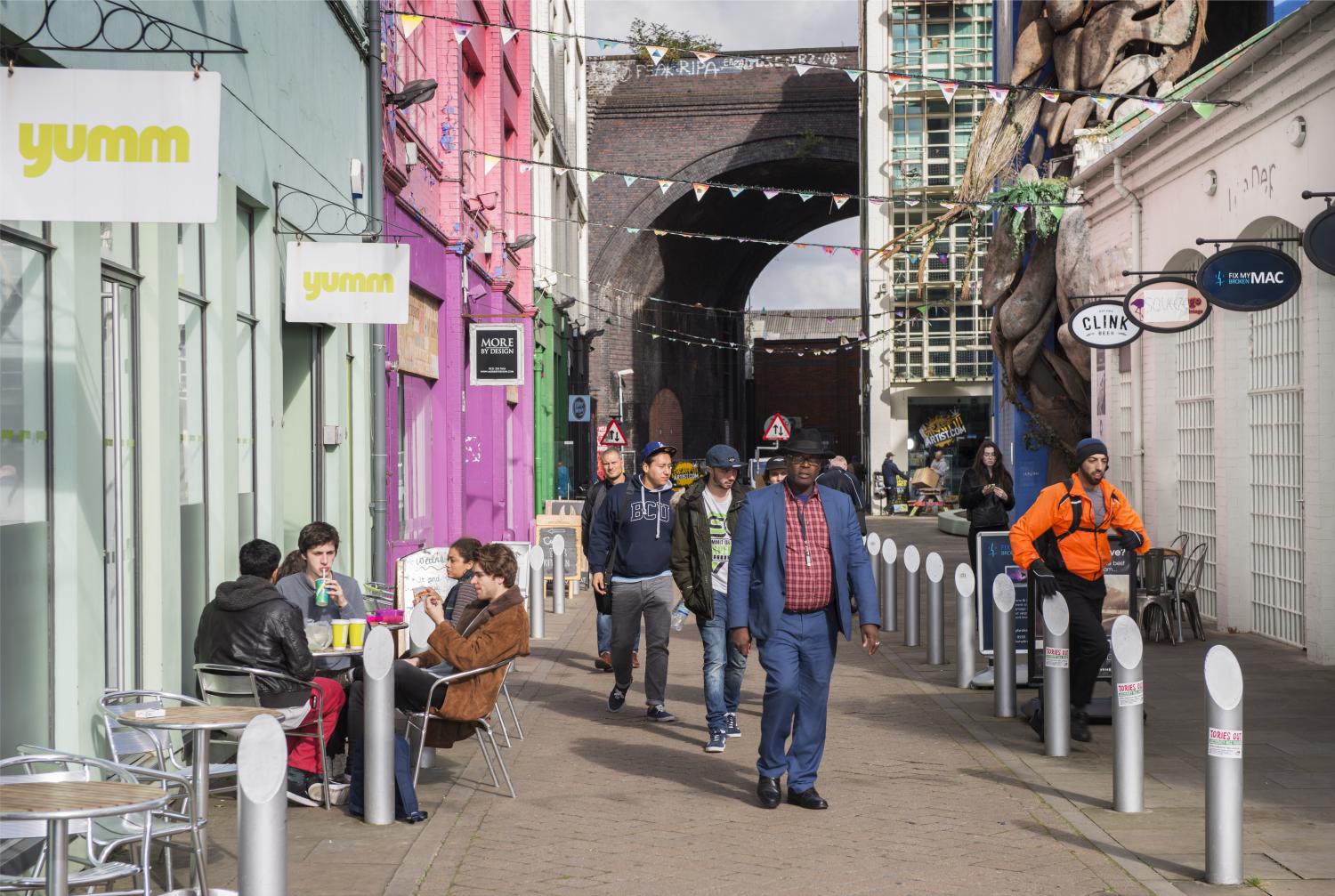 General view of mixed use redevelopment with people walking down the street.