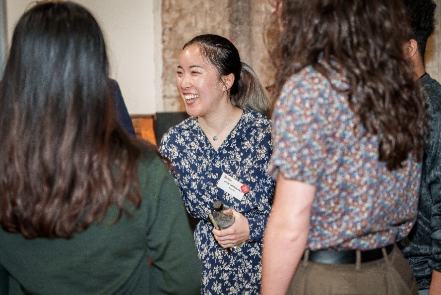 A person holding a bottle of water laughs with two other people