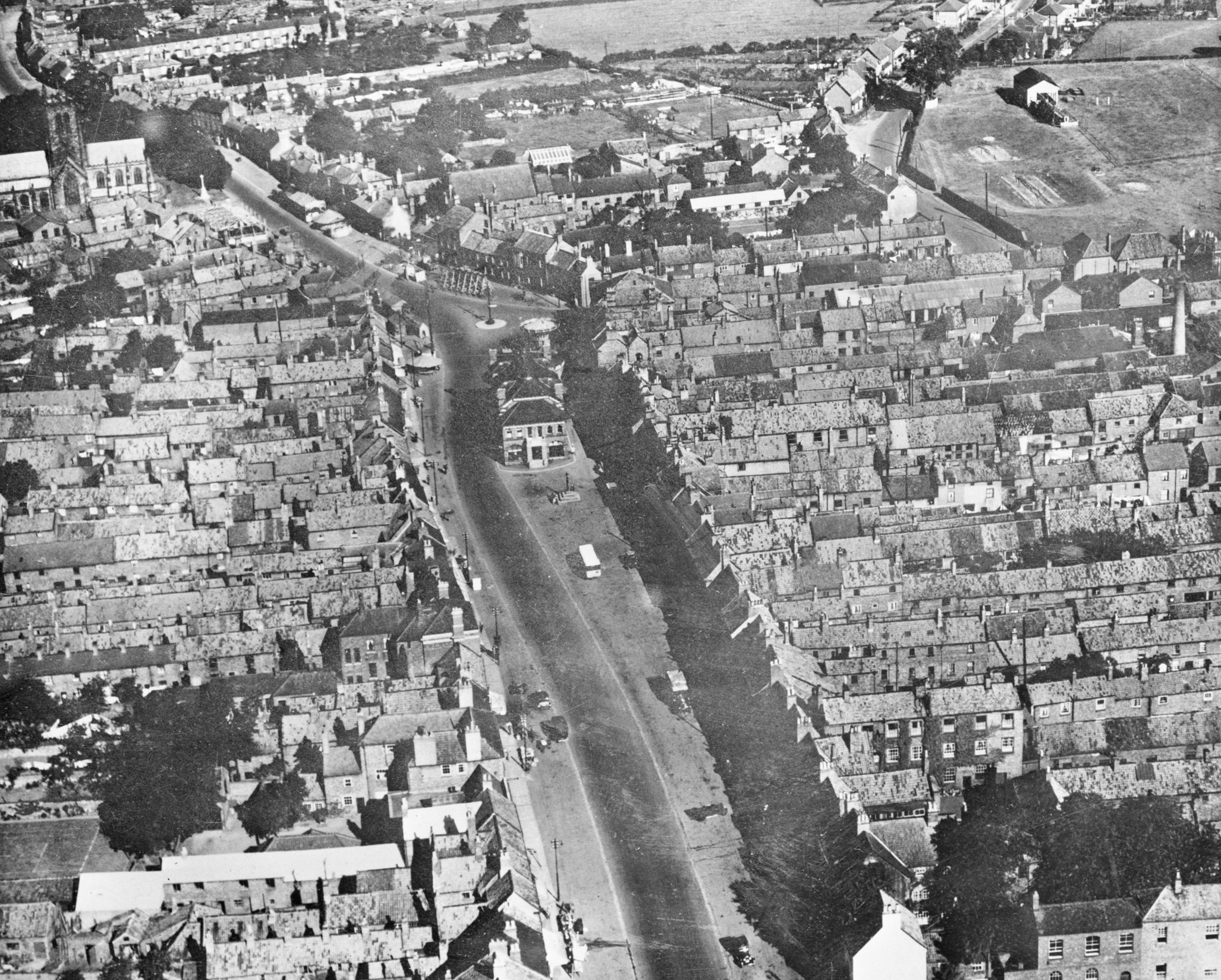 A black and white archive aerial view of a High Street.
