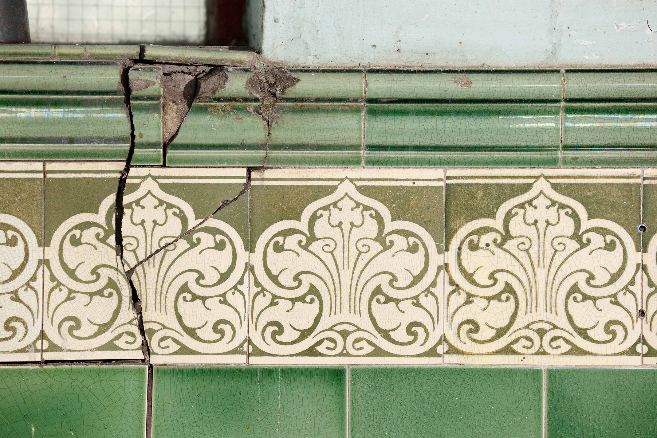 Original Pilkington tiles in green and cream. Some of them are cracked.