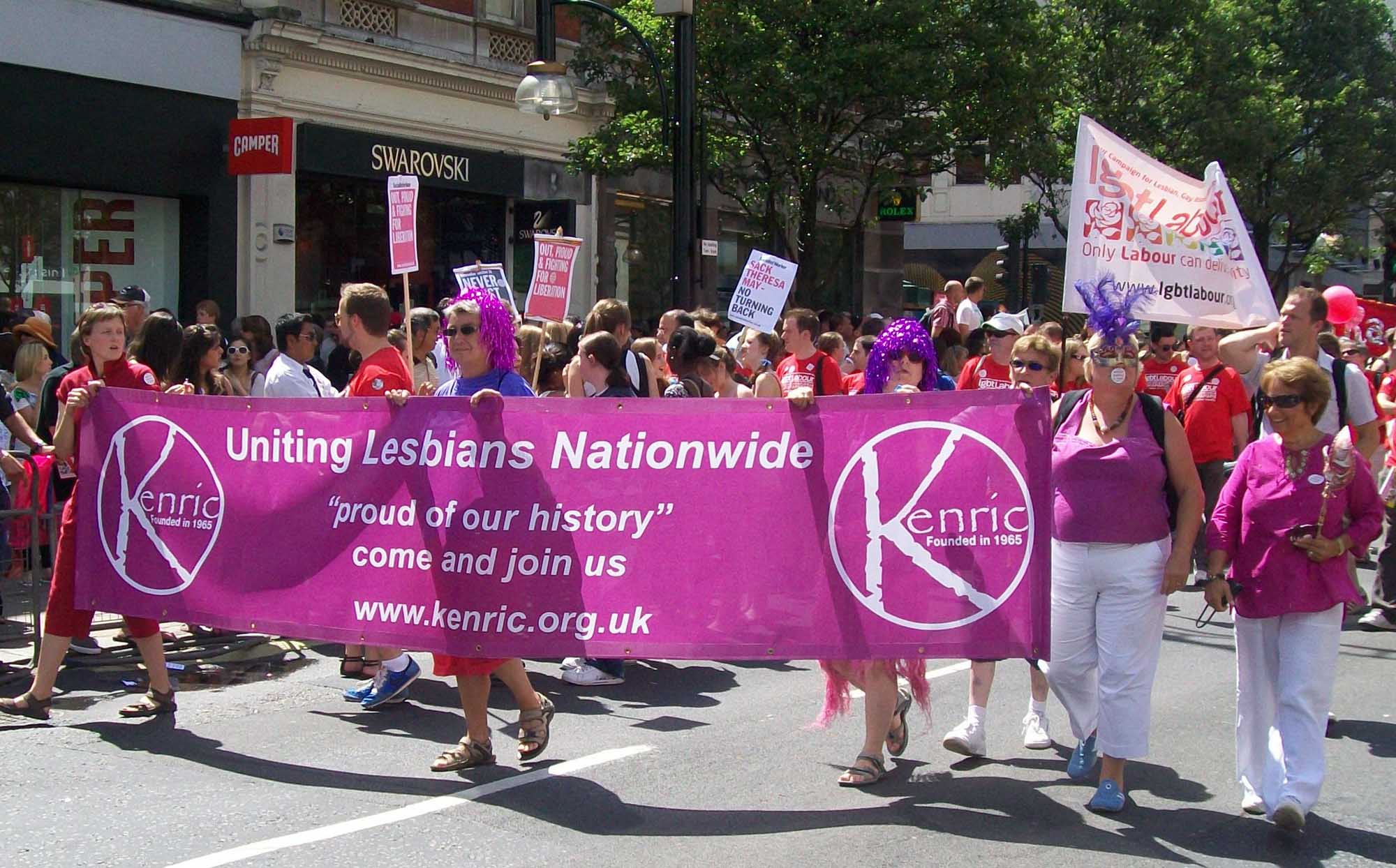 Marchers carrying Kenric banner with wording: 
Uniting Lesbians Nationwide
"proud of our history"
come and join us
www.kenric.org.uk