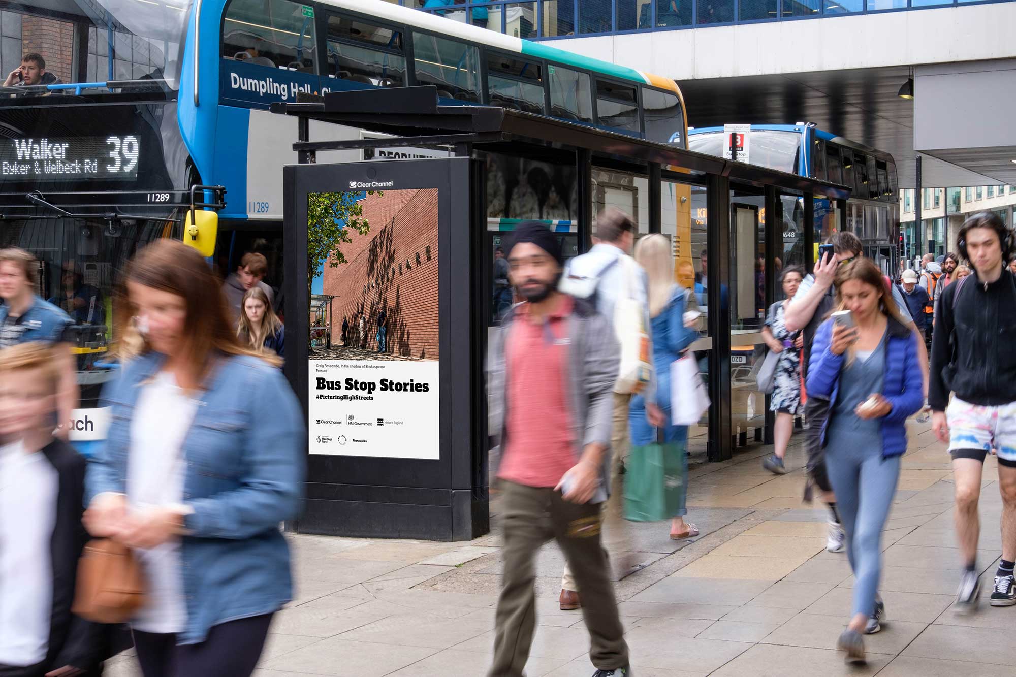 People walking past a bus stop.