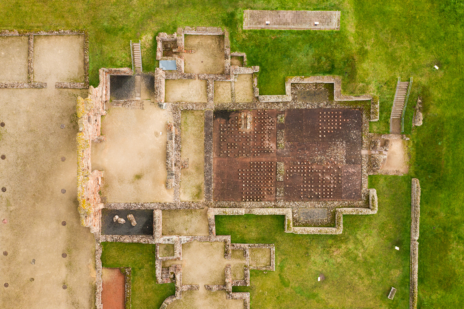 A birds-eye view of a cruciform foundation with hypocaust stacks in the two right-hand rooms. 
