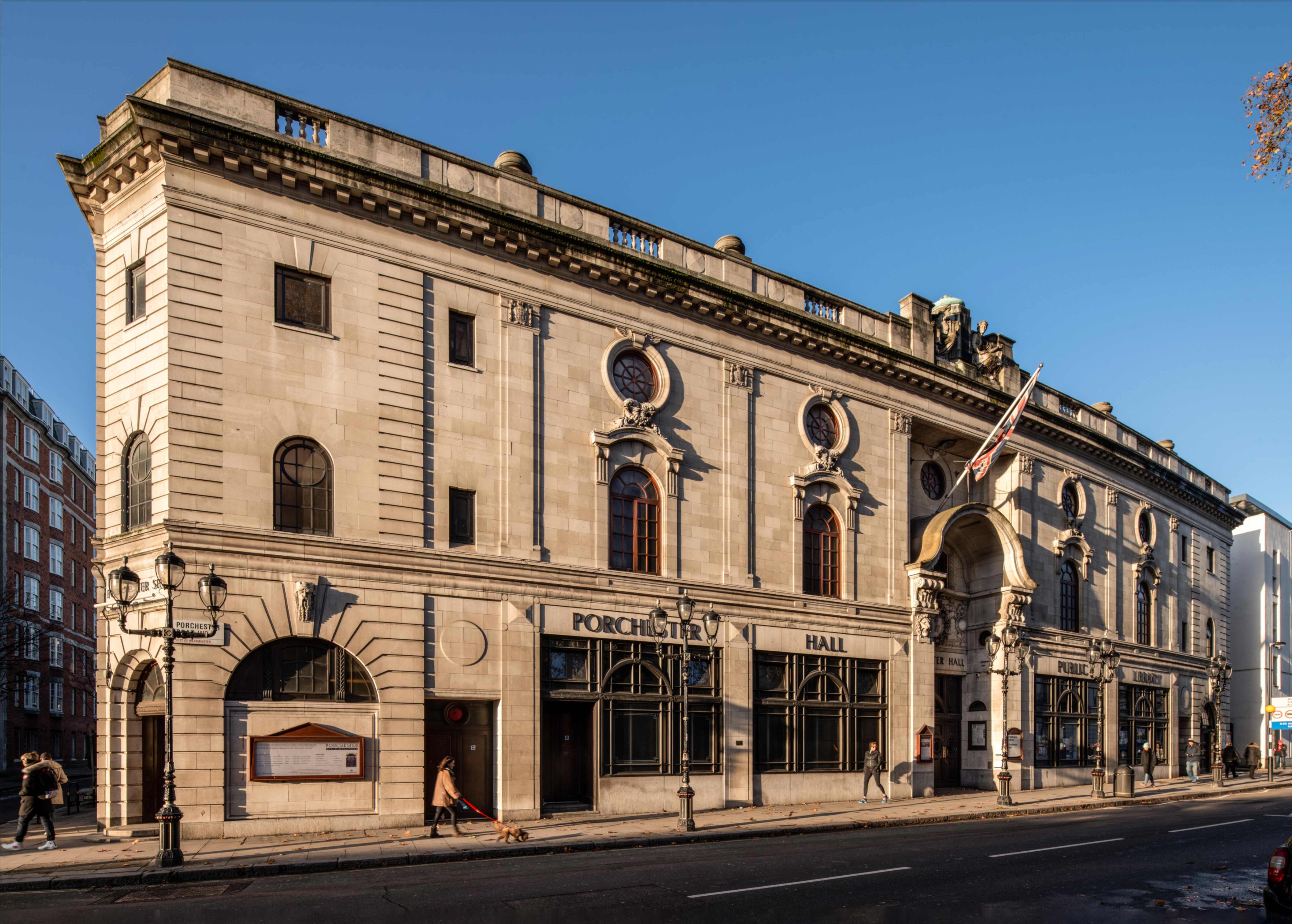 Exterior of a three-storey Georgian sandstone urban building bearing letters reading "Porchester Hall"