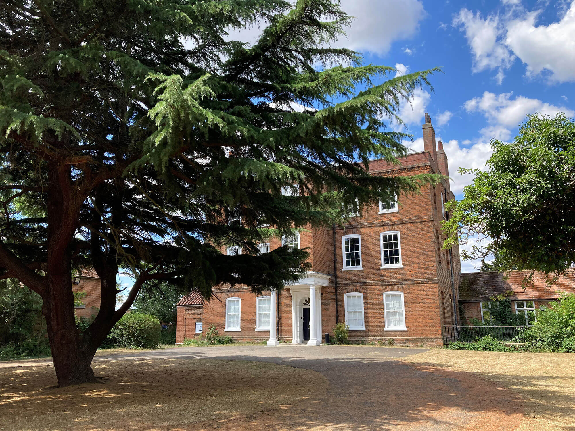 Photo of a large brick house with a tree in front