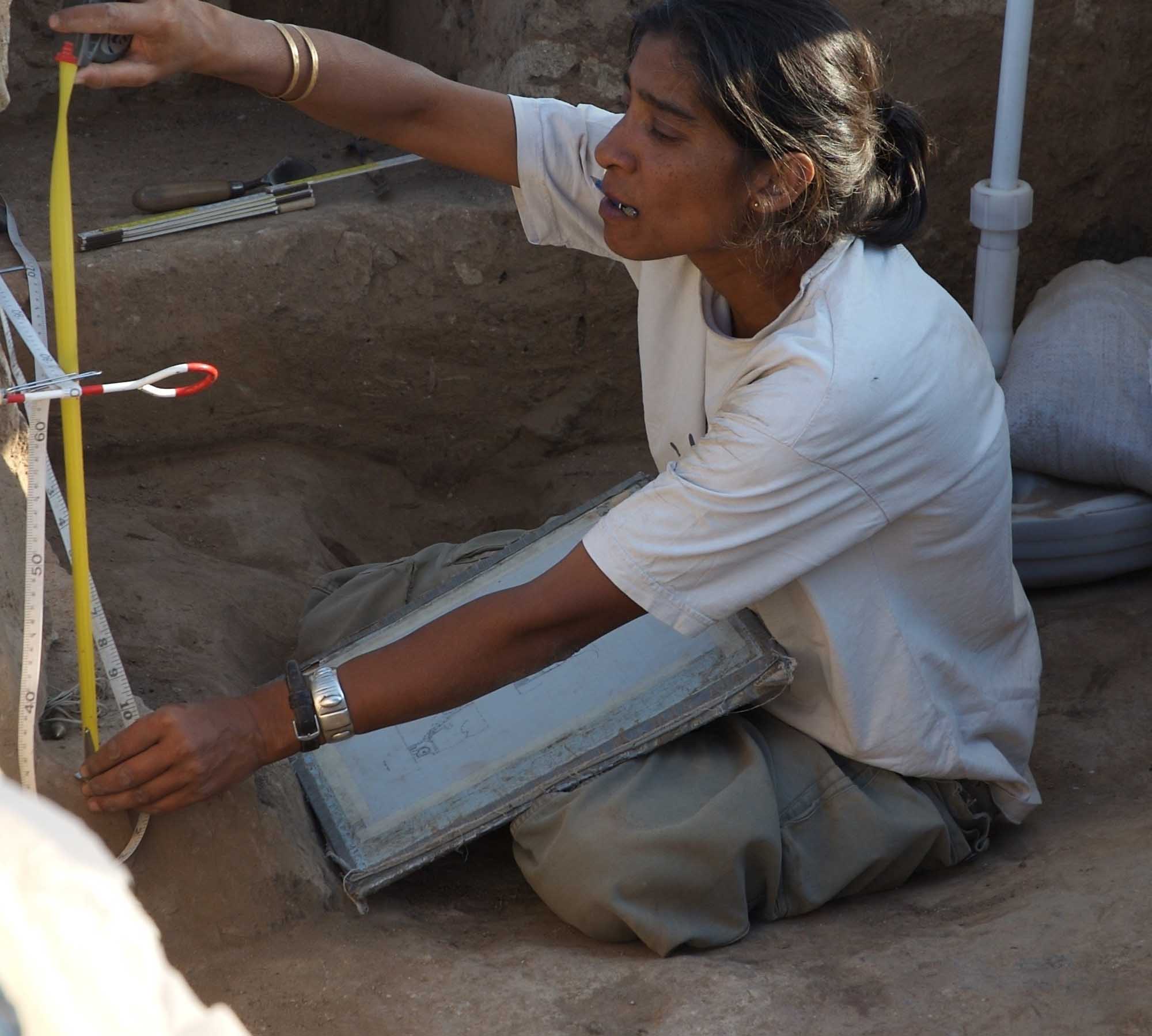 Archaeologist Shahina Farid recording and drawing features at a site.