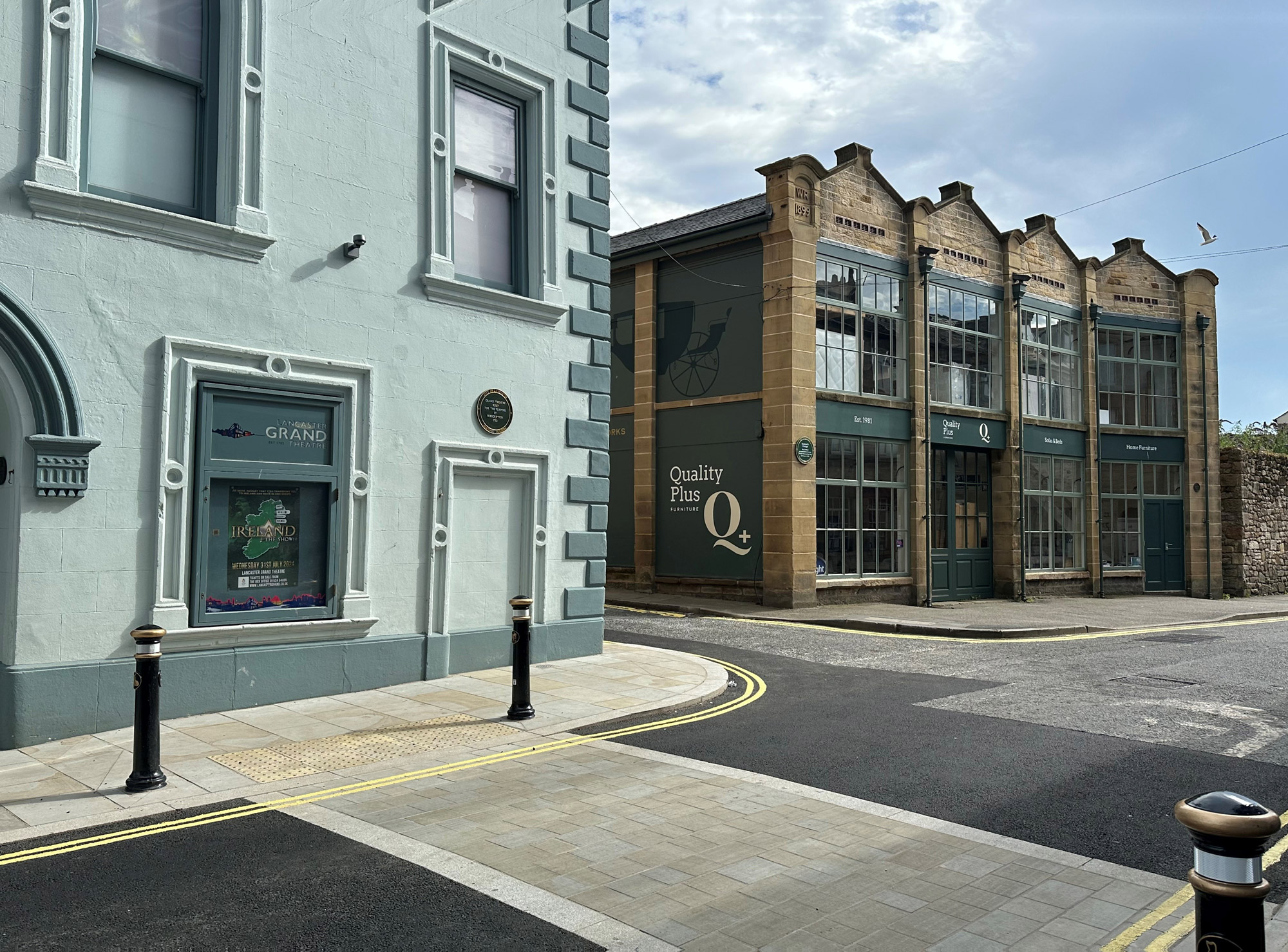 Colour photo showing part of a theatre building next to newly restored, 2-storey stone carriage showrooms building.