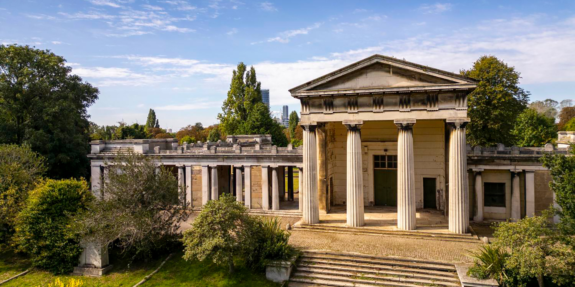A neo-classical building in a park area. 