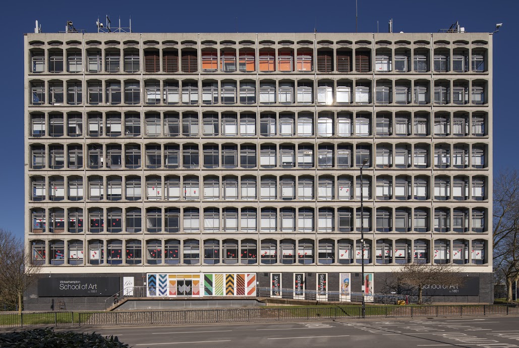 Modern 7-storey concrete buildling. Building signage on the far left and far right on the ground floor is not all visible but large lettering reads: School of Art.