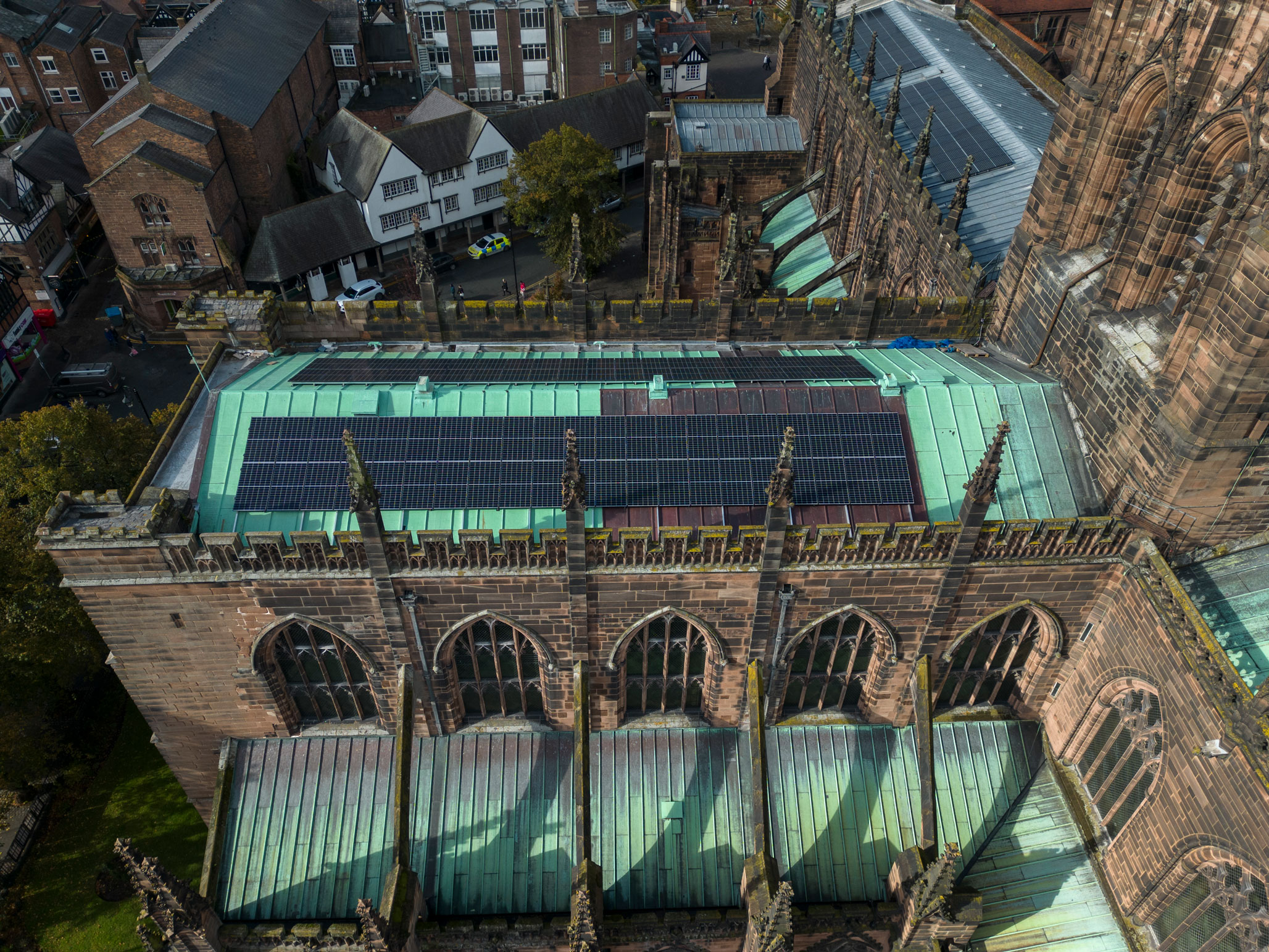 A detail, seen from the air, of the roof of a cathedral with solar panels installed.